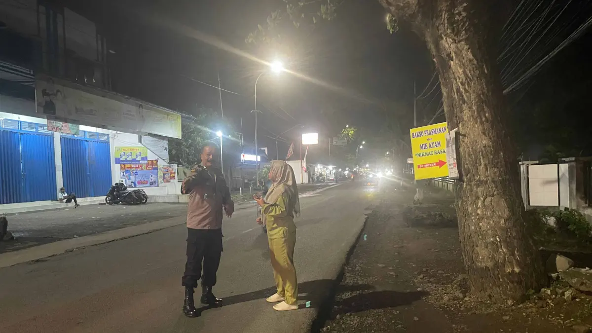 LOKASI KEJADIAN: Korban bersama anggota Polsek Gondangwetan di lokasi jambret merampas tas korban, Rabu (22/4) malam. (POLRES PASURUAN KOTA FOR JAWA POS RADAR BROMO)