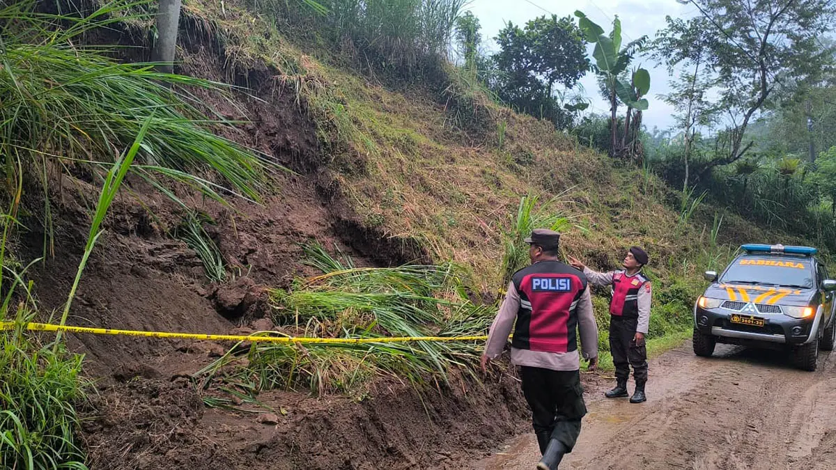 GARIS POLISI: Anggota Polsek Nongkojajar saat memasang garis polisi di tebing yang sempat longsor. Langkah ini dilakukan, untuk mengingatkan pengguna jalan, agar lebih berhati-hati melintas. (Polsek Nongkojajar/Radar Bromo)