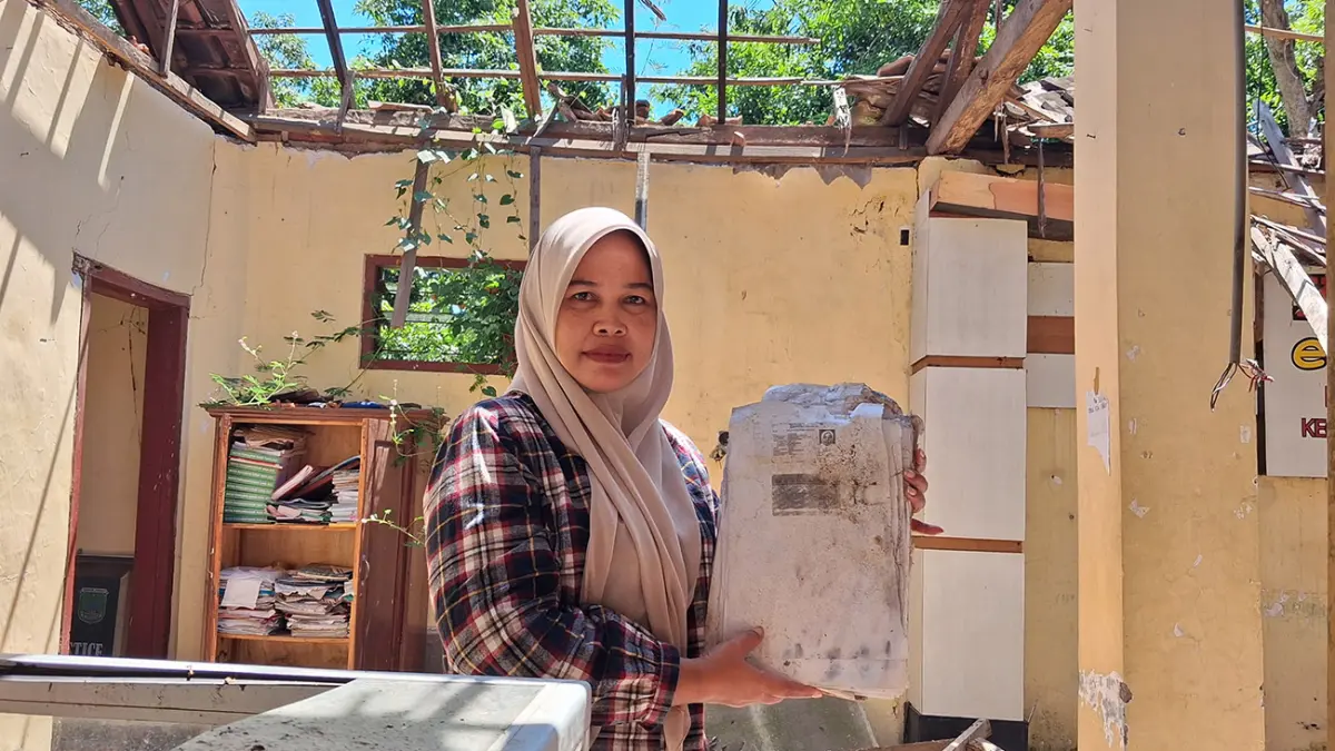 HANCUR: Kaur keuangan Desa Sumberanyar, Nguling, menunjukan berkas yang rusak karena reruntuhan dan hujan. (Fuad Alyzen/ Radar Bromo)