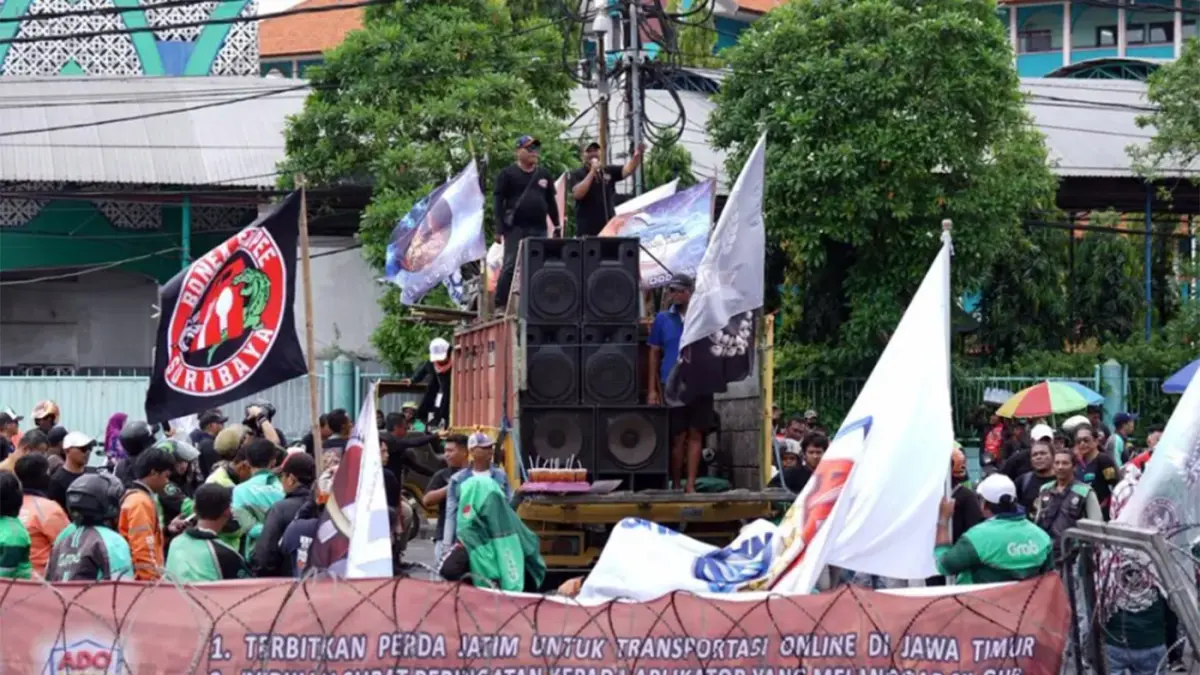 BERORASI: Ratusan ojol dan taksol saat demo dan berorasi di depan Kantor DPRD Jatim. Mereka menuntut kejelasan regulasi dan perlindungan. (MUS PURMADANI/ RADAR SURABAYA)