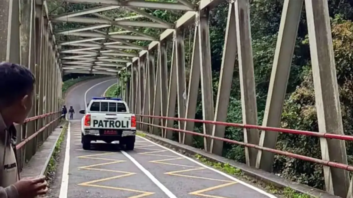 DIHALAU: Petugas Tahura Raden Soerjo mengimbau warga agar tidak berhenti di sepanjang jembatan yang menghubungkan jalur Cangar-Pacet. (Rizal JPRM)