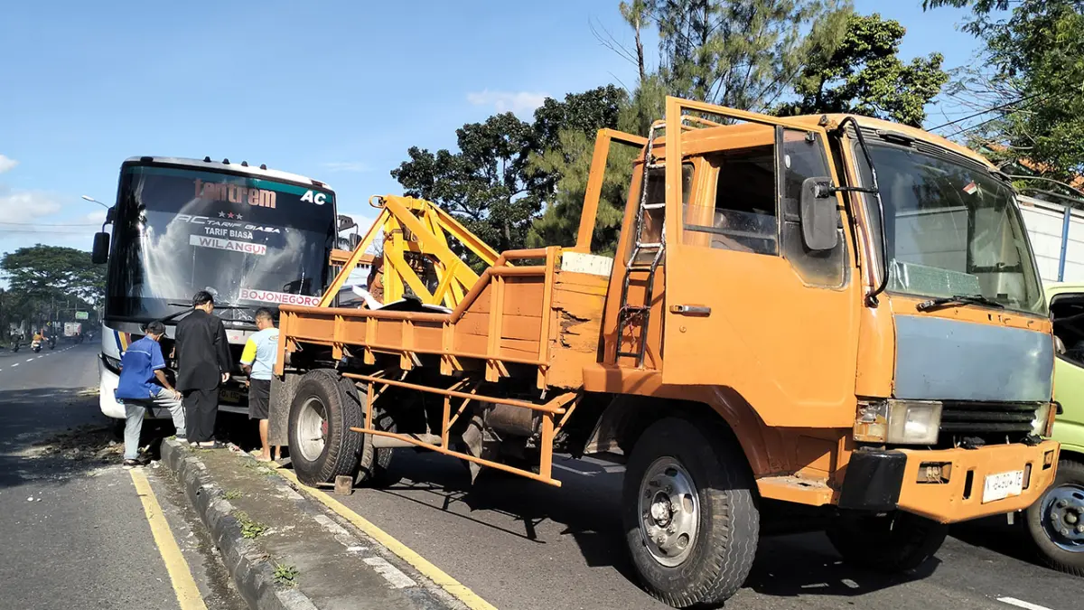 DIDEREK: Kondisi Bus Tentrem yang naik median dan menabrak PJU di Purwodadi, Kabupaten Pasuruan saat diderek petugas. (Rizal Syatori/ Radar Bromo)