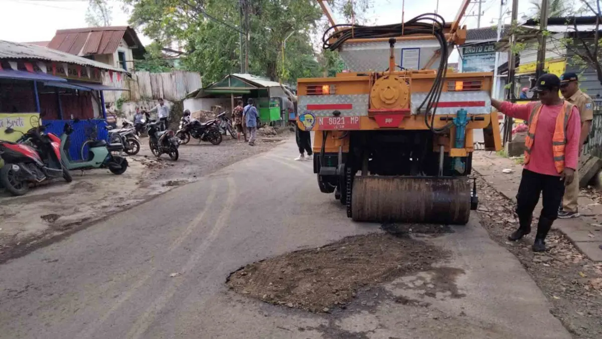 DIPERBAIKI: Sejumlah pekerja melakukan tambal sulam Jalan Gending-Sebaung, Kabupaten Probolinggo. (AGUS FAIZ MUSLEH/JAWA POS RADAR BROMO )