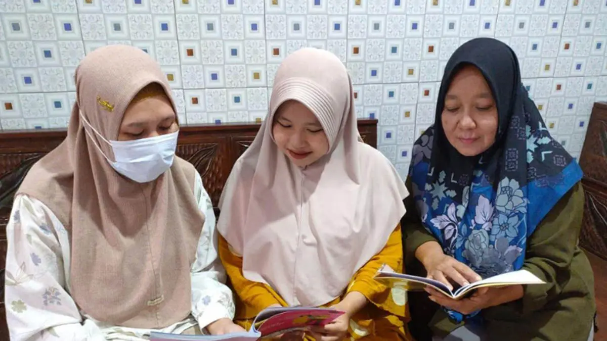 PANTAU: Petugas kesehatan saat memberikan pendampingan kepada salah satu ibu hamil dengan memantau buku KIA (Kesehatan Ibu dan Anak). (Puskesmas Purwodadi for Radar Bromo)
