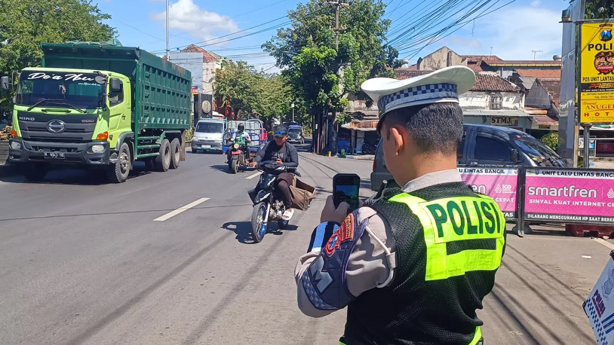 POTRET: Anggota Satlantas Polres Pasuruan saat menerapkan handheld untuk menindak pelanggar. (Istimewa)