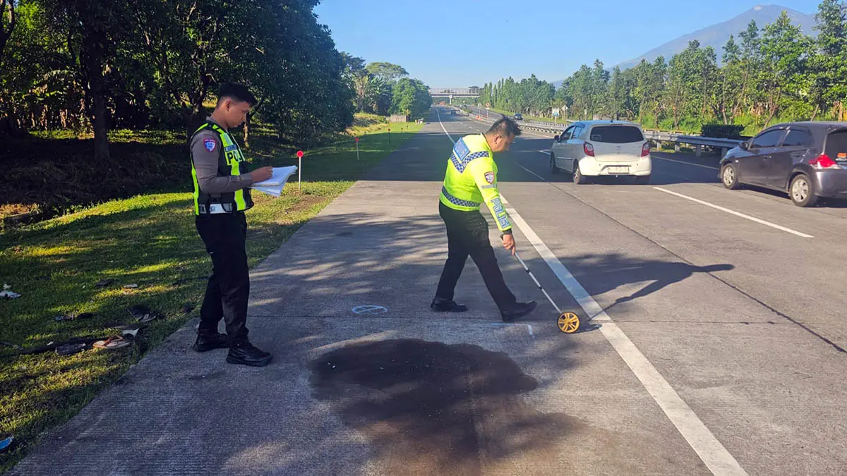 CARI BUKTI: Petugas Satlantas Polres Pasuruan saat melakukan olah TKP di jalan tol, tempat insiden kecelakaan yang menewaskan Mochammad Roziqul Murtadho, 25, pemuda asal Gresik. (Polres Pasuruan for Radar Bromo)