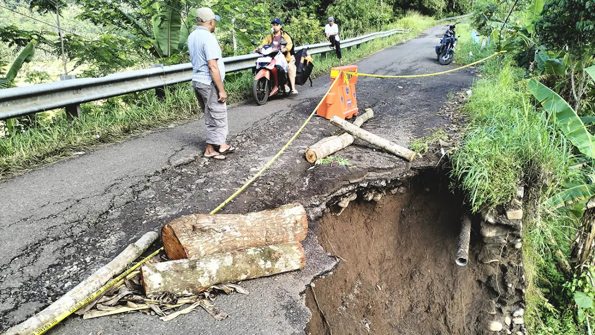 AMBLES: Ruas jalan di Dusun Paleran, Desa Andungsari, Kecamatan Tiris ambles tergerus air hujan. Ruas jalan ini penghubung Desa Andungsari ke Andungbiru. (Achmad Arianto/ Radar Bromo)