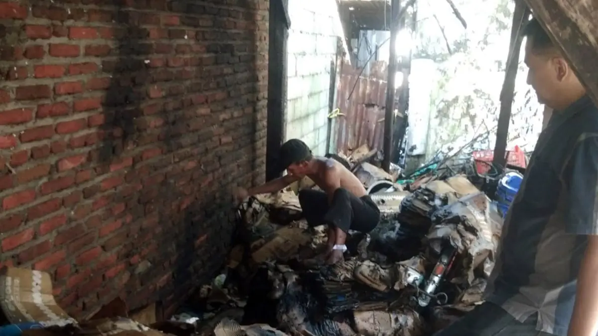 TERBAKAR: Sejumlah anggota kepolisian mendatangi gudang Rongsokan milik Nur Kholis, di Desa Raci, Kecamatan Bangil, yang terbakar.