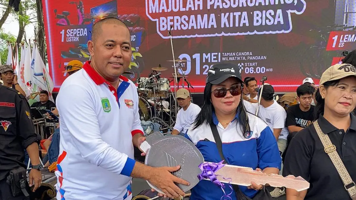 BAWA PULANG : Wakil Ketua Bidang Hukum dan Investasi TP3D, Suryono Pane bersama pemenang sepeda motor. (Foto: Pemkab pasuruan for Jawa Pos Radar Bromo)