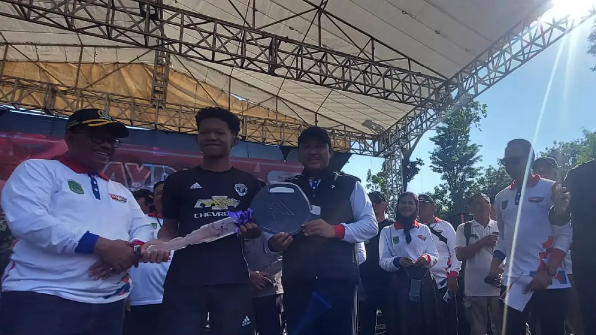 BERUNTUNG: Bupati Mas Rusdi didampingi Ketua DPRD Samsul Hidayat menyerahkan hadiah sepeda motor. (Foto: Pemkab pasuruan for Jawa Pos Radar Bromo)