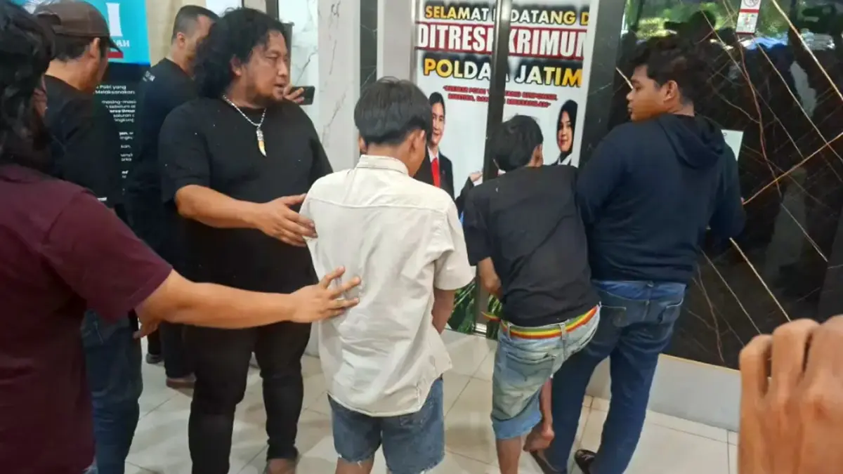 DIBEKUK: SAS (kaus hitam, kaki tertembak) dan JF (baju krem) digiring oleh unit jatanras ke Gedung Ditreskrimum Polda Jatim kemarin (4/5) setelah membegal dua wisatawan di Bukit Premium, Kabupaten Pasuruan. (Mahrus/ Radar Surabaya)