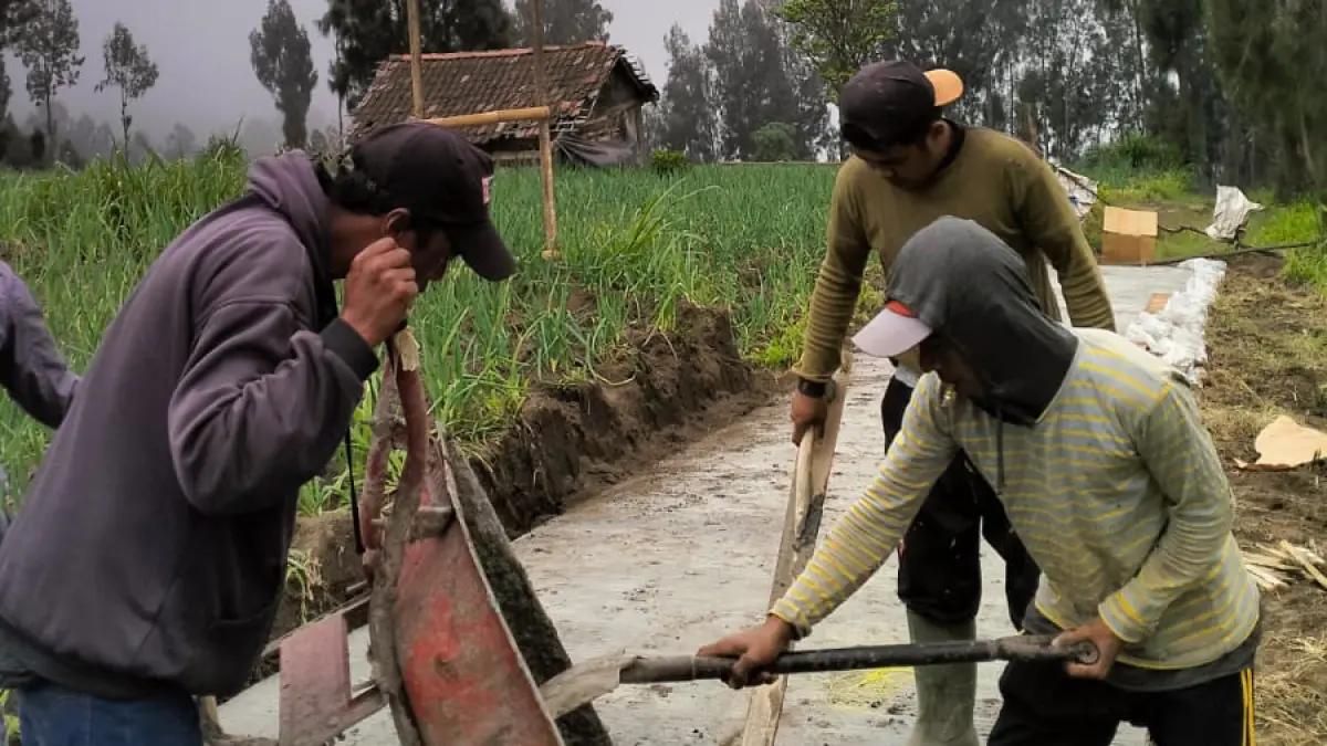 GUYUB: Sejumlah warga merabat beton jalan usaha tani di Desa Ngadisari, Kecamatan Sukapura. (PEMDES NGADISARI FOR JAWA POS RADAR BROMO)