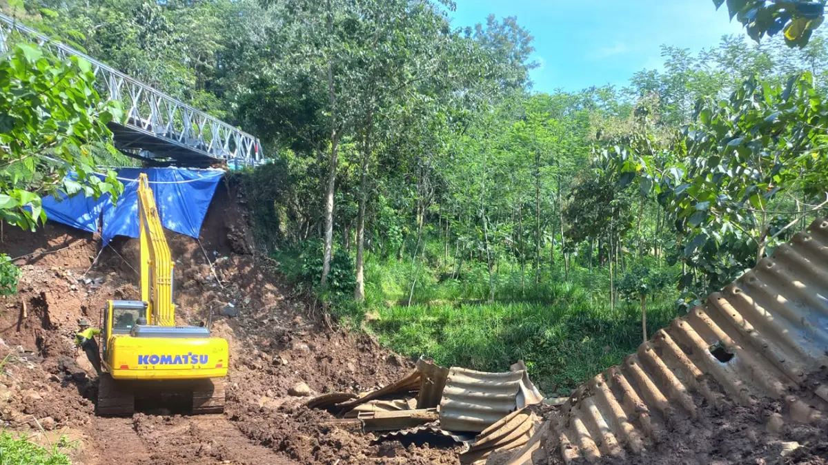 DIKERUK: Sebuah ekskavator yang tengah membersihkan sisa gorong-gorong baja (armco) di bawah Jembatan Duren, Desa Negororejo, Kecamatan Lumbang, Kabupaten Probolinggo, Rabu (6/5) pagi. (Inneke Agustin/ Radar Bromo)