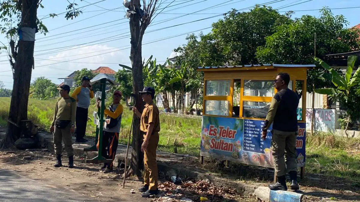 HARUS BERSIH: Personel Satpol PP bersama pihak Kecamatan Kraksaan dan DLH melakukan penertiban lapak PKL rusak dan kumuh di wilayah Desa Bulu, Selasa (5/5). (Foto: Agus Faiz Musleh/Jawa Pos Radar Bromo)