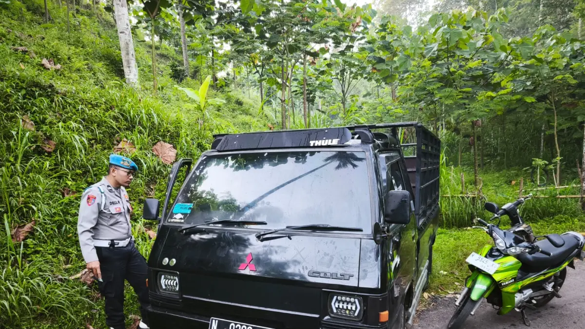 PERIKSA: Petugas kepolisian saat mengecek mobil yang diduga hasil tindak kejahatan yang gagal digondol pelaku. (polsek nongkojajar)