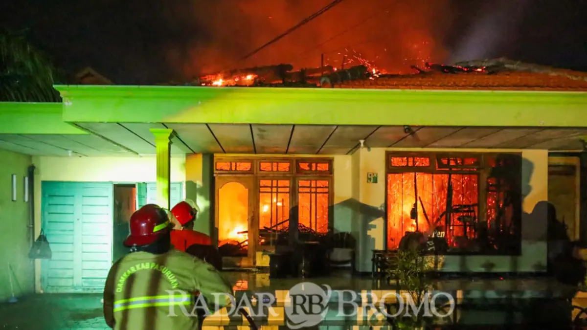 Petugas pemadam kebakaran saat berupaya memadamkan api di rumah dan salon yang terbakar di Tapaan, Bugul Kidul, Pasuruan. (Mokhamad Zubaidillah/ Radar Bromo)