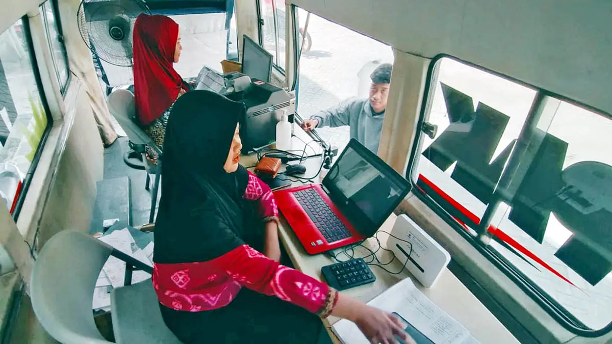 LAYANI: Petugas Dispendukcapil saat memberikan layanan kepada pemohon KTP saat hendak melakukan pencetakan di armada Walk Thru. (Dokumen Radar Bromo)