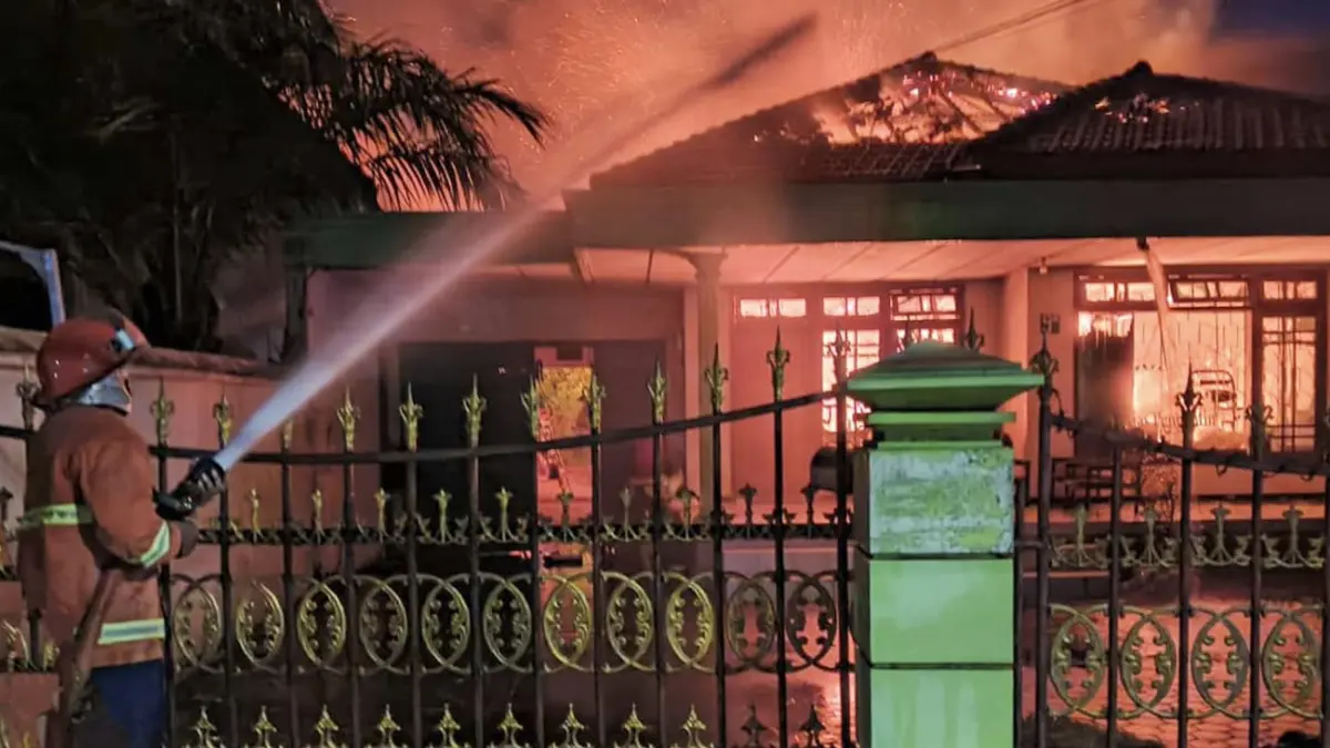 Petugas damkar saat berupaya memadamkan si jago merah yang mengamuk di rumah dan salon Citra di Tapaan, Bugul Kidul, Kota Pasuruan. (Mokhamad Zubaidillah/ Radar Bromo)