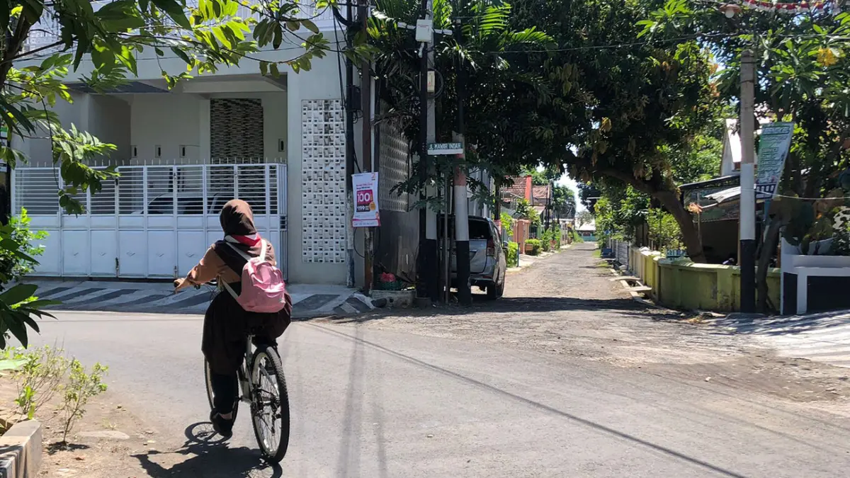 TKP: Seorang pesepeda saat melintas di depan Jalan Mawar Indah yang menjadi lokasi dugaan pencurian terhadap sepeda atlet ISSI Kota Probolinggo, berinisial BAK, 14, warga Kecamatan Mayangan, Kota Probolinggo, Jumat (8/5). (Inneke Agustin/ Radar Bromo)