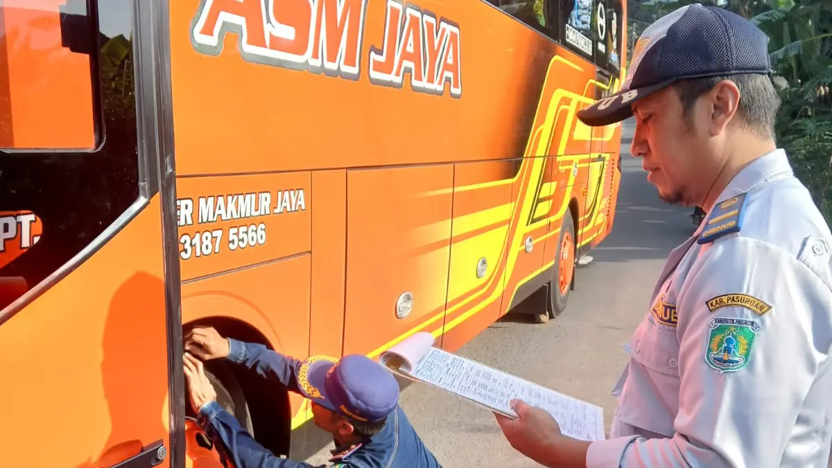 DIPERIKSA: Petugas Dishub Kabupaten Pasuruan, memeriksa kelayakan bus sebelum digunakan untuk outing class. (BUSTHOMI/JAWA POS RADAR BROMO)