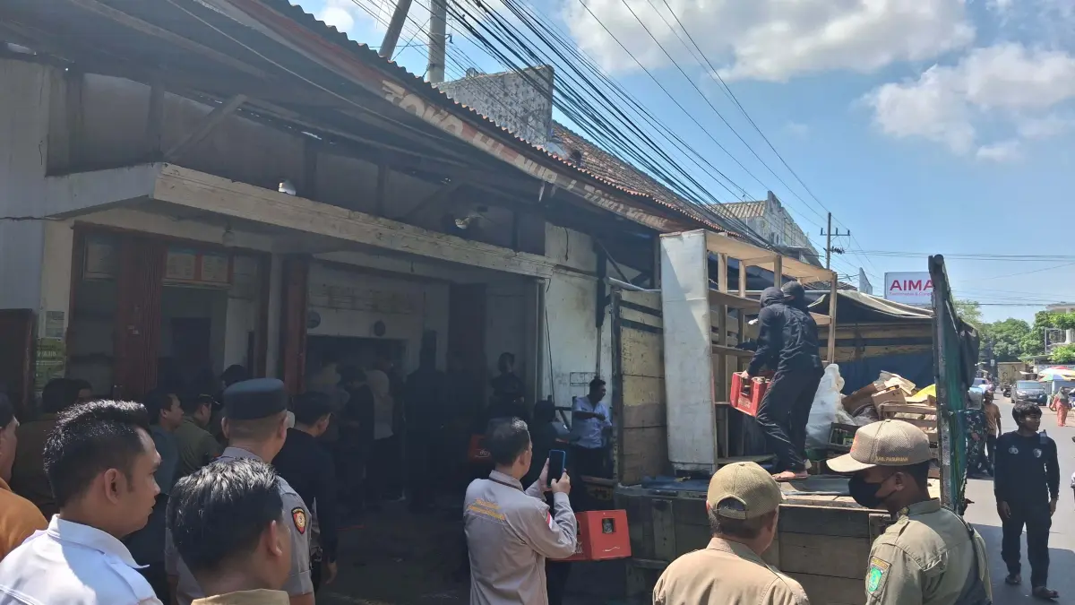 EKSEKUSI: Sejumlah petugas mengangkut barang-barang dari sebuah roko di Jalan Desa Sumberdawesari, Kecamatan Grati, Kabupaten Pasuruan, Rabu (13/5). (FUAD ALYZEN/JAWA POS RADAR BROMO)