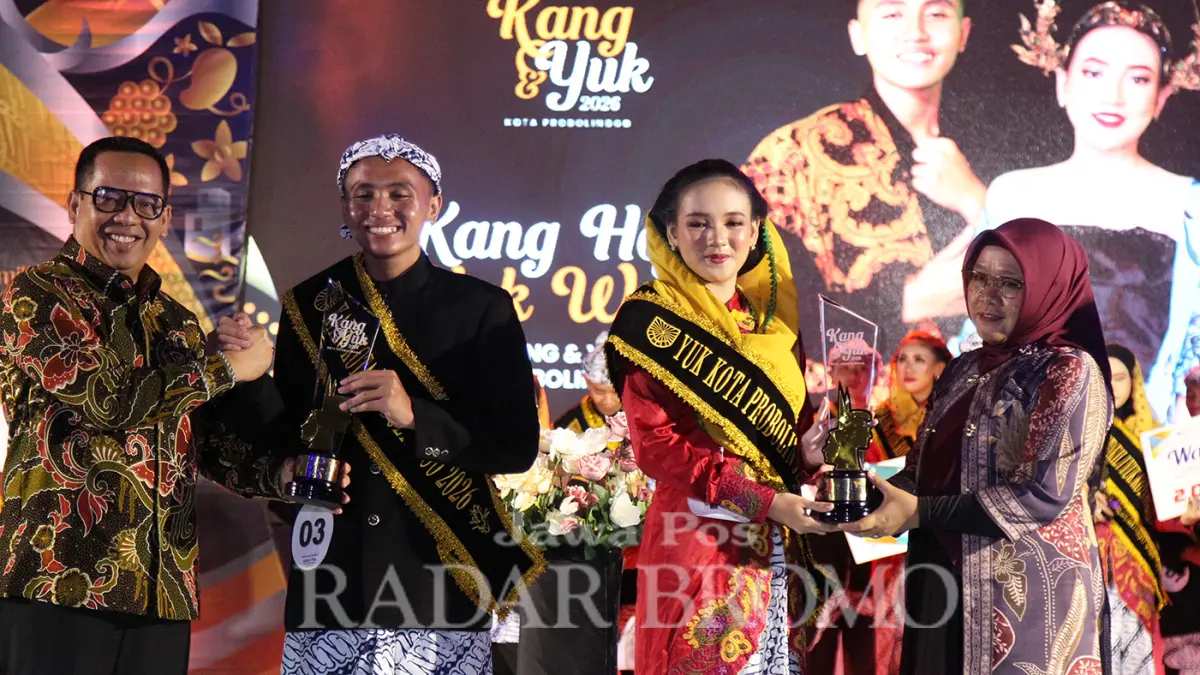 DUTA WISATA: Kang M. Tsaqif Al Hafizh dari SMAN 2 Kota Probolinggo dan Yuk Wyne Velina dari SMAK Mater Dei Probolinggo saat mendapat anugerah juara di malam puncak ajang Duta Wisata Kang dan Yuk Kota Probolinggo 2026, di halaman kantor Satpol PP Kota Probolinggo, (17/5) malam. (Mokhamad Zubaidillah/ Radar Bromo)