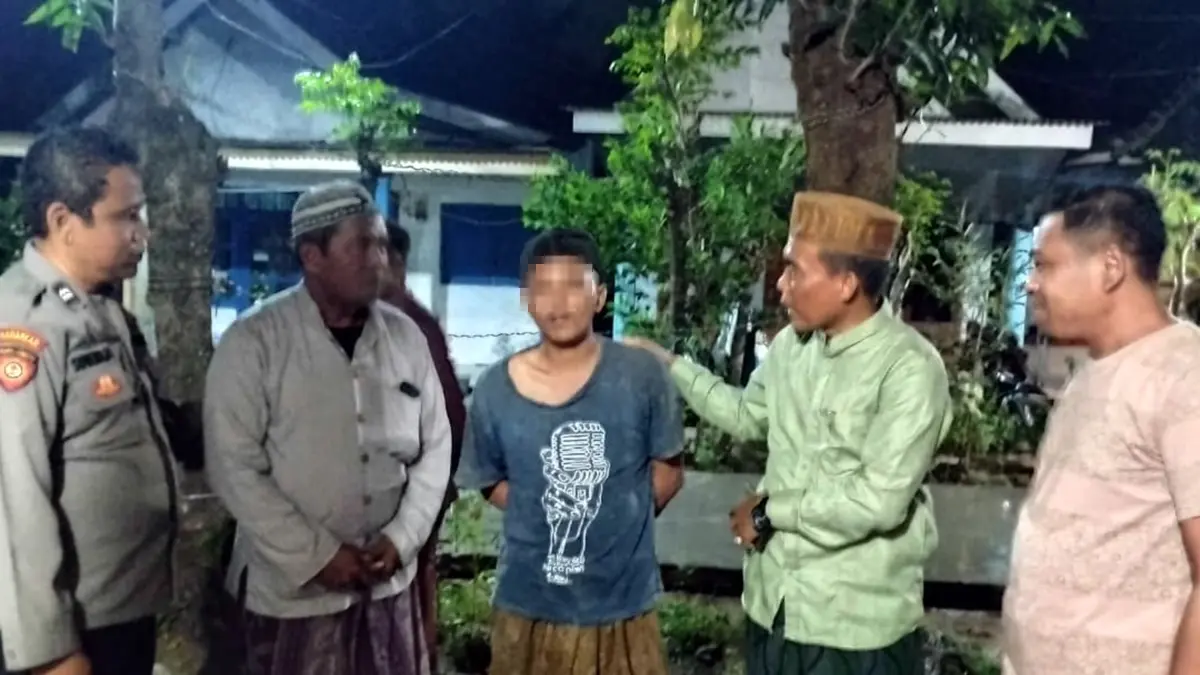 DIKIRA MALING: Warga dan petugas kepolisian saat mengamankan pemuda yang dikira maling. 