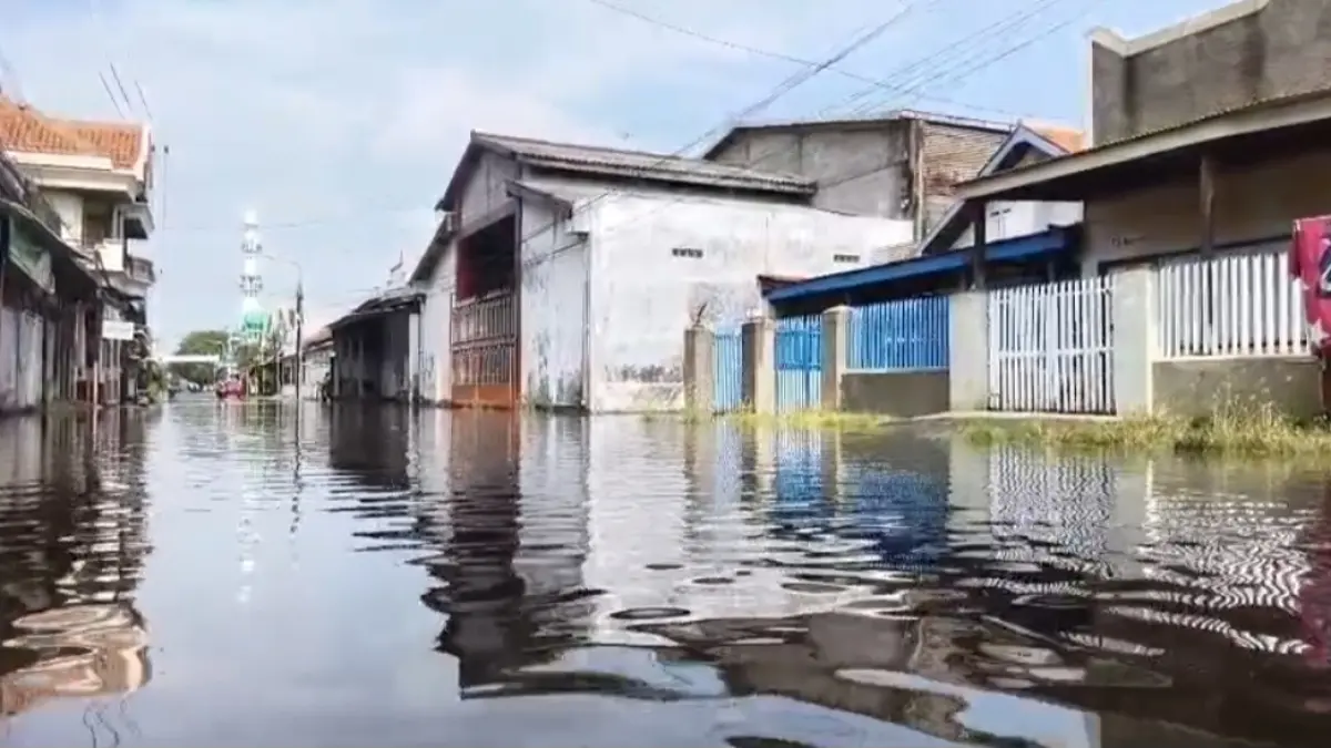 SEBELUM SURUT: Personel Satpolairud berjalan di genangan akibat banjir rob di Jalan MT Haryono Kelurahan Mandaranrejo, Senin (18/5) pagi. (Foto: Fuad Alyzen Jawa Pos Radar Bromo)