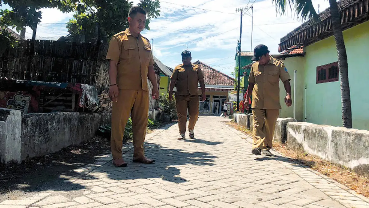 KOKOH: Sekretaris Desa Ngepoh Andre Septian (tengah) bersama perangkat desa mengecek lokasi pavingisasi di Dusun Lajuk.