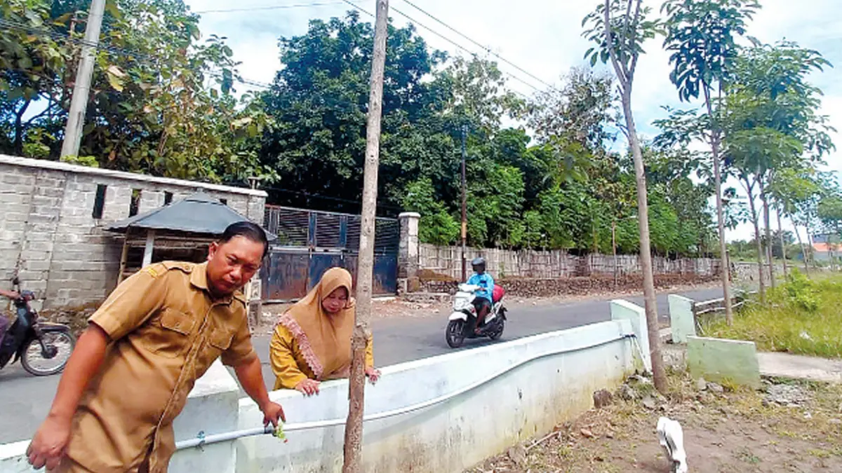 RINDANG: Kasi Pembangunan Desa Watuwungkuk Dafid Prasasti bersama Kepala TP PKK Desa Watuwungkuk Listiyawati mengecek sistem penyiraman pohon tabebuya di Desa Watuwungkuk.