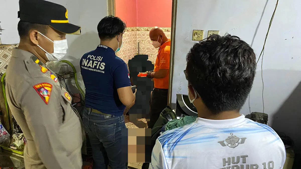 EVAKUASI: Petugas dan warga saat mengevakuasi korban, Handy Harsono. Ia ditemukan meninggal, di dalam kamar mandi rumahnya. (Polres Pasuruan Kota for Radar Bromo)