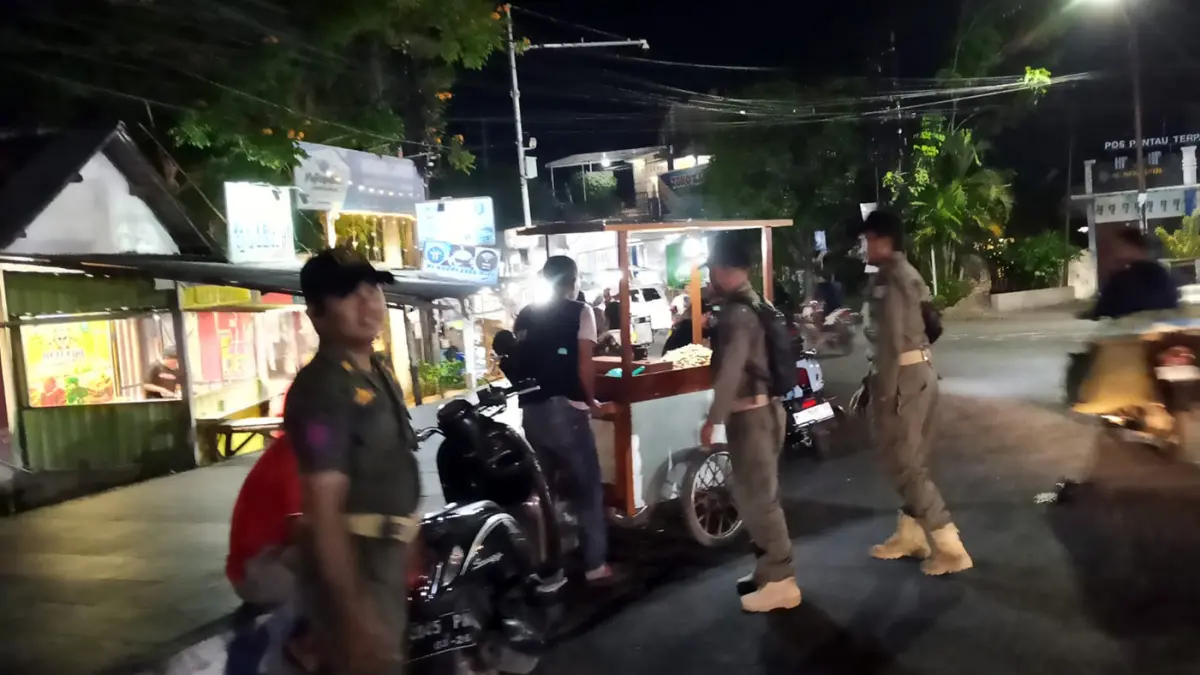 PENERTIBAN: Anggota Satpol PP Kota Probolinggo menghalau PKL di Bundaran Gladak Serang, Jumat malam (22/5).