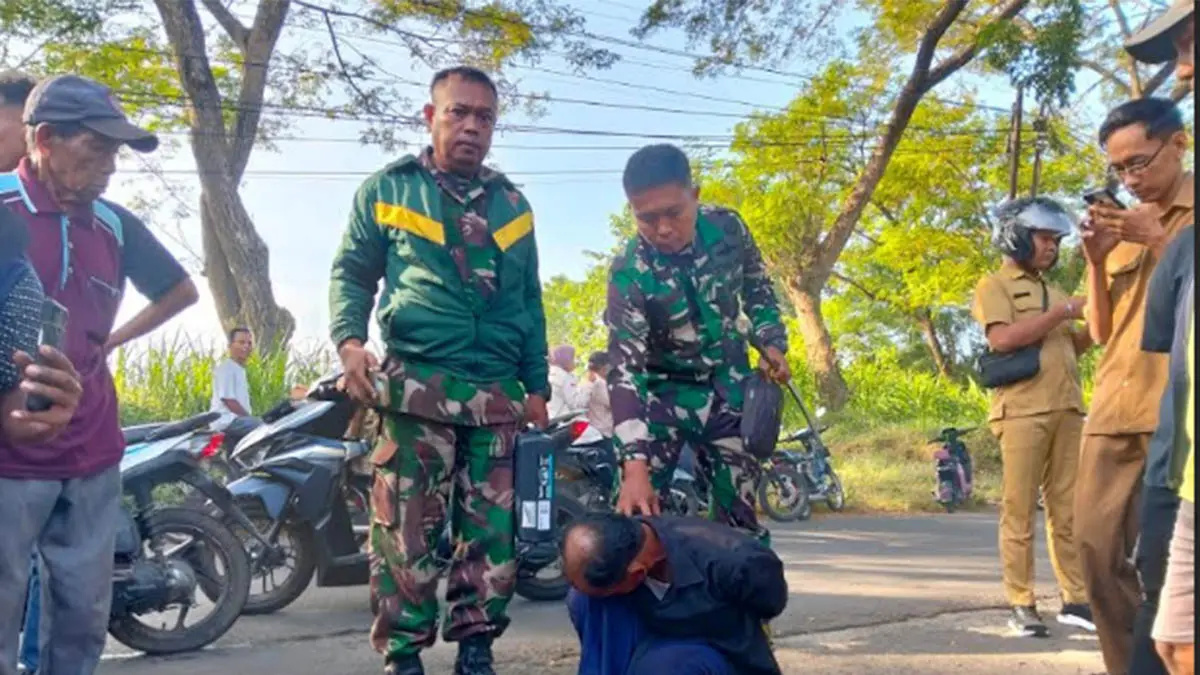 TAK SENDIRIAN: KB (duduk) terduga pencuri motor di SDN Kalipang saat diamankan personel Babinsa. (Foto: dok Jawa Pos Radar Bromo)