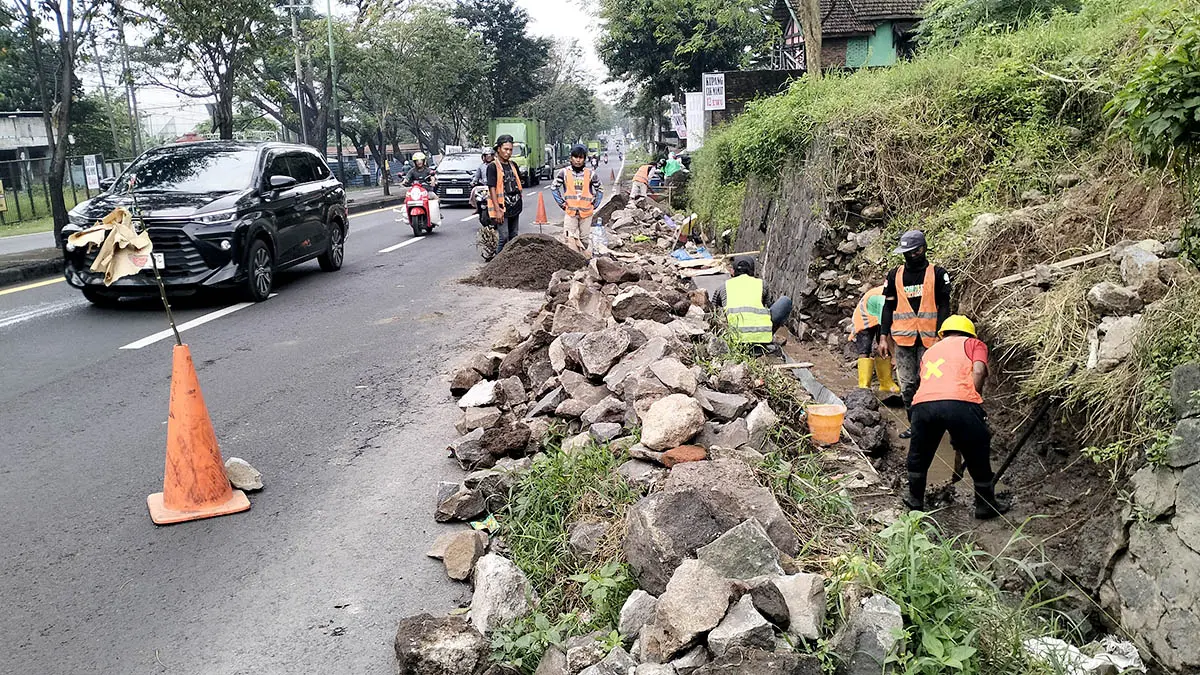 DIBEHANI: Sejumlah pekerja tampak sibuk menggarap perbaikan saluran air di tepi Jalan Bypass Pandaan, tepatnya di wilayah Desa Plintahan, Kecamatan Pandaan. (Rizal Syatori/Radar Bromo)