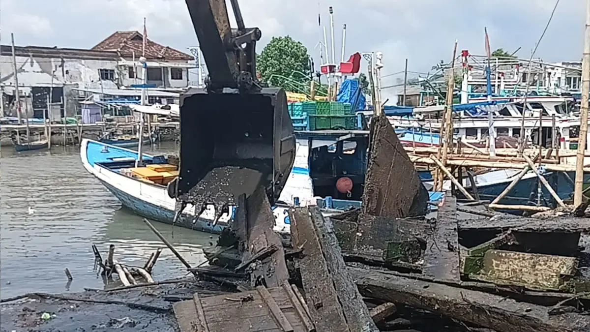 ANGKAT: Alat berat yang dikerahkan Pemkot Pasuruan untuk menormalisasi Sungai Gembong dan mengangkat bangkai kapal. (Fuad Alyzen/Radar Bromo)