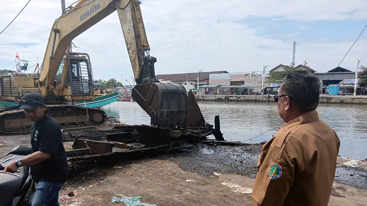 PENGERUKAN: Pengerukan Sungai Gembong di Kota Pasuruan yang memanfaatkan alat berat. Sejauh ini, kegiatan normalisasi itu, terkendala oleh perahu nelayan. (Camat Panggungrejo for Radar Bromo)