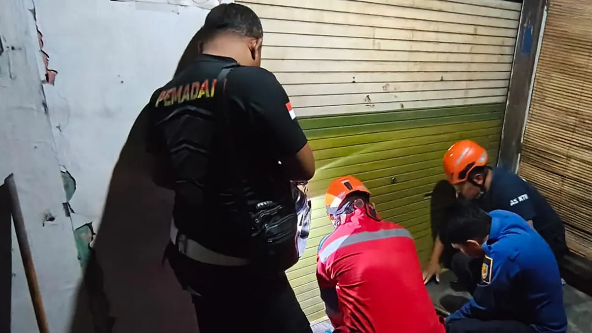 EVAKUASI: Tim Damkar Satpol PP Kota Probolinggo berusaha membuka gembok rolling door pegadaian di Kelurahan Triwung Kidul, Kecamatan Kademangan, Jumat (29/5) malam.&nbsp;(DAMKAR SATPOL PP KOTA PROBOLINGGO FOR JAWA POS RADAR BROMO)