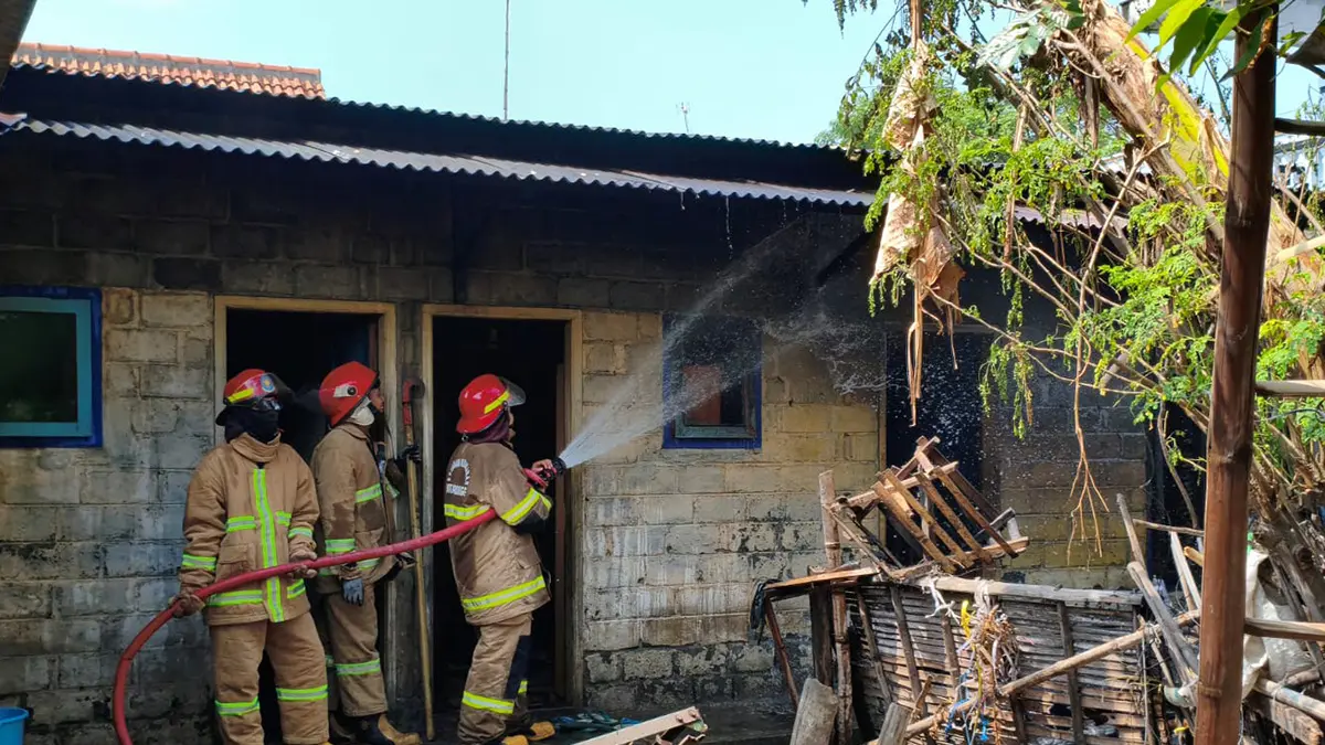 SEMPROT: Tim Damkar Satpol PP Kota Probolinggo memadamkan api di dapur rumah warga Kelurahan Kedungasem, Kecamatan Wonoasih, Muhammad Drajat, Sabtu (23/5).&nbsp;(INNEKE AGUSTIN/JAWA POS RADAR BROMO)