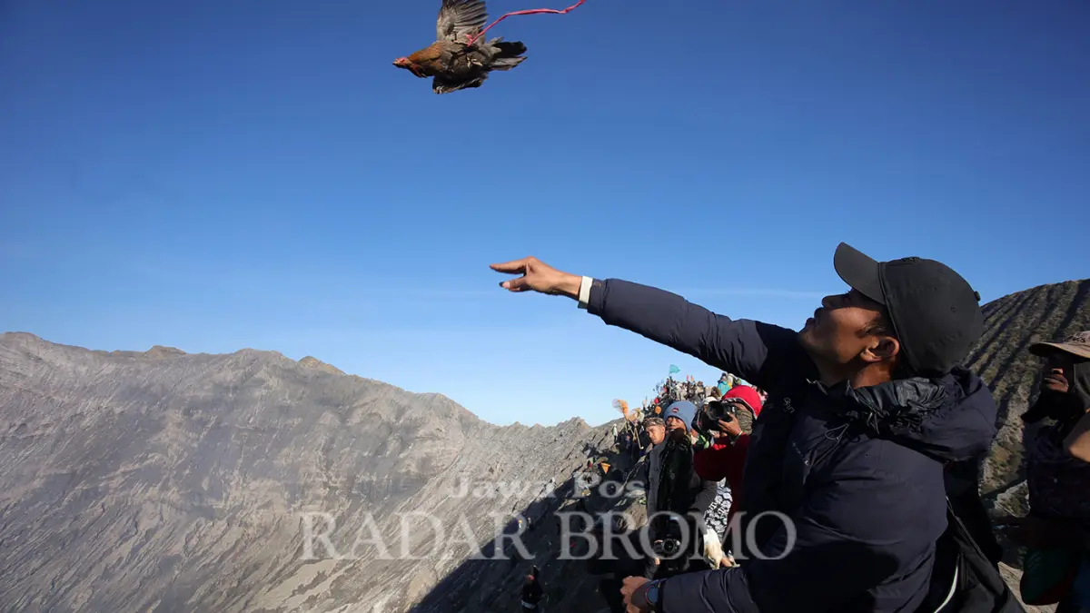 Salah satu warga Tengger melarung ayam ke kawah Gunung Bromo di perayaan Yadnya Kasada, Senin (1/6). (Mokhamad Zubaidillah/ Radar Bromo)