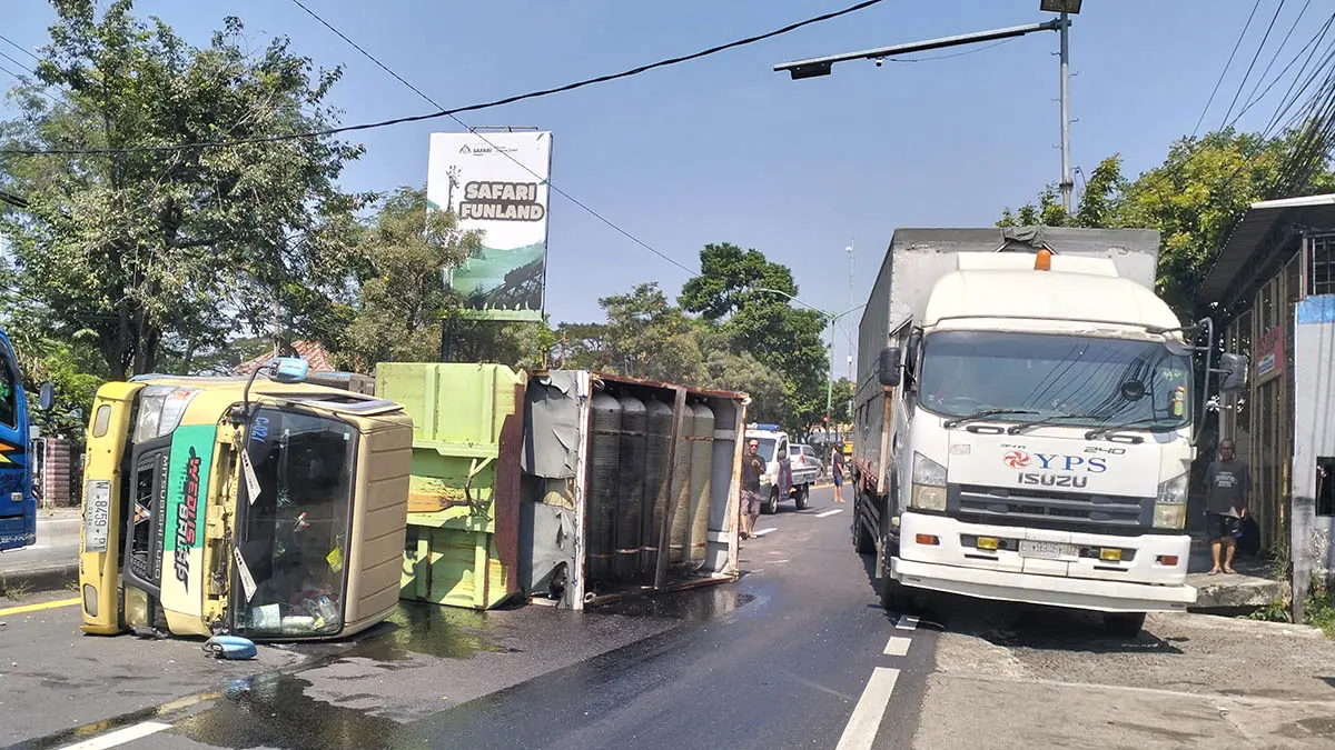 SEBELUM DIEVAKUASI: Truk yang terguling di utara simpang empat patung sapi, Desa Tawangrejo, Kecamatan Pandaan. (Foto: Rizal f Syatori/Jawa Pos Radar Bromo)