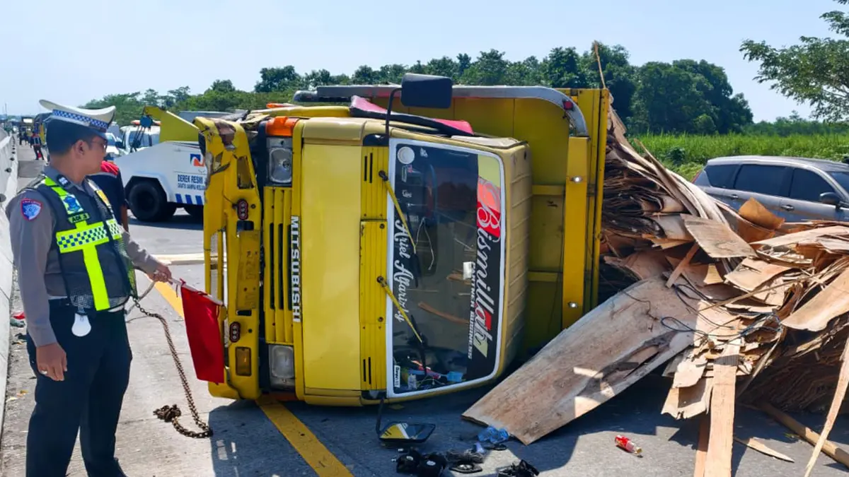 Celaka: Truk bermuatan tripleks yang dikemudikan Agung Umar Subagio terguling di Jalan Tol Paspro Kilometer 813/A wilayah Desa Sumberdawesari, Kecamatan Grati.&nbsp;(PJR 4 JATIM FOR JAWA POS RADAR BROMO)