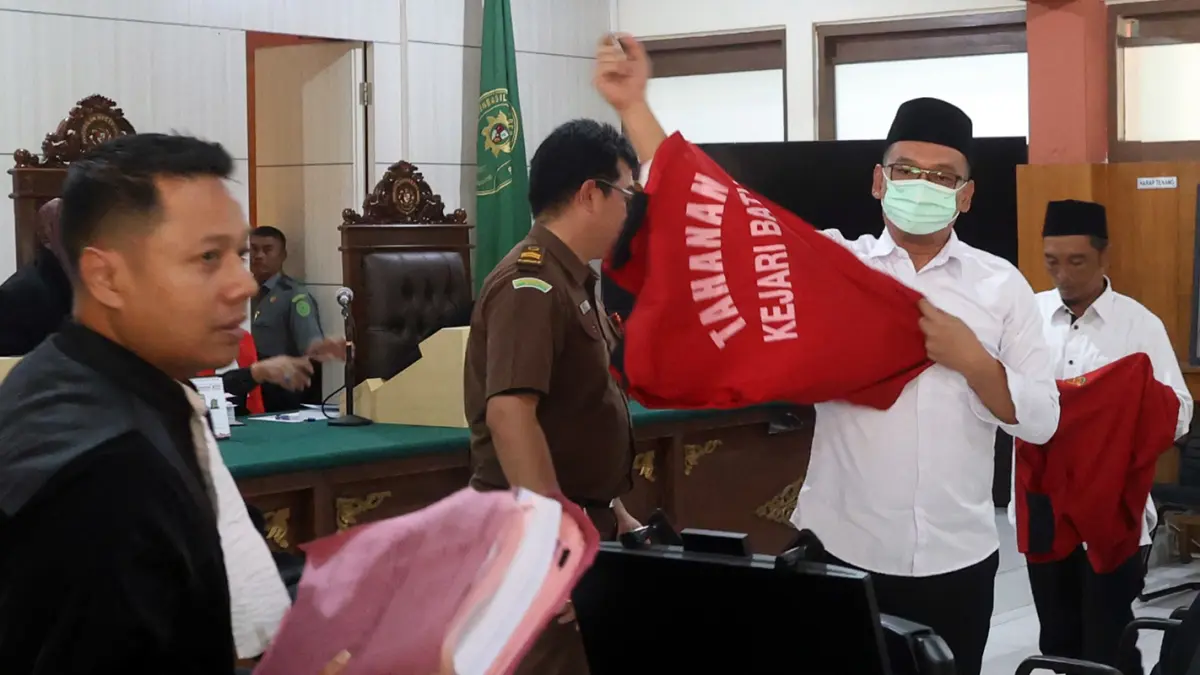 DISIDANG: Terdakwa Agus Saleman (pakai kacamata) dan Suyitno saat mengenakan rompi tahanan kejaksaan usai ikuti sidang di PN Malang. (Darmono/ Radar Malang)