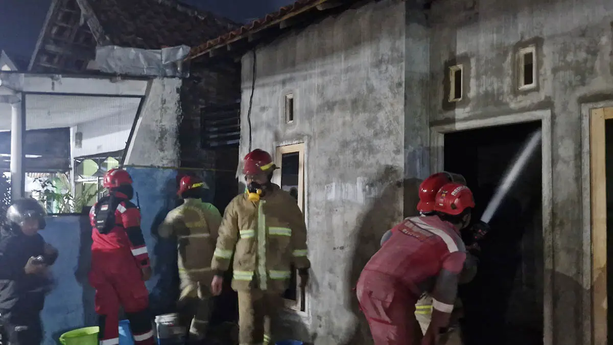 SEMPROT: Petugas Damkar Satpol PP Kota Probolinggo saat melakukan pemadaman di rumah Burhan, 67, warga Kelurahan Kebonsari Kulon, Kecamatan Kanigaran, Kota Probolinggo, yang mengalami kebakaran pada Rabu (3/6) malam. (Foto: Damkar for Jawa Pos Radar Bromo)