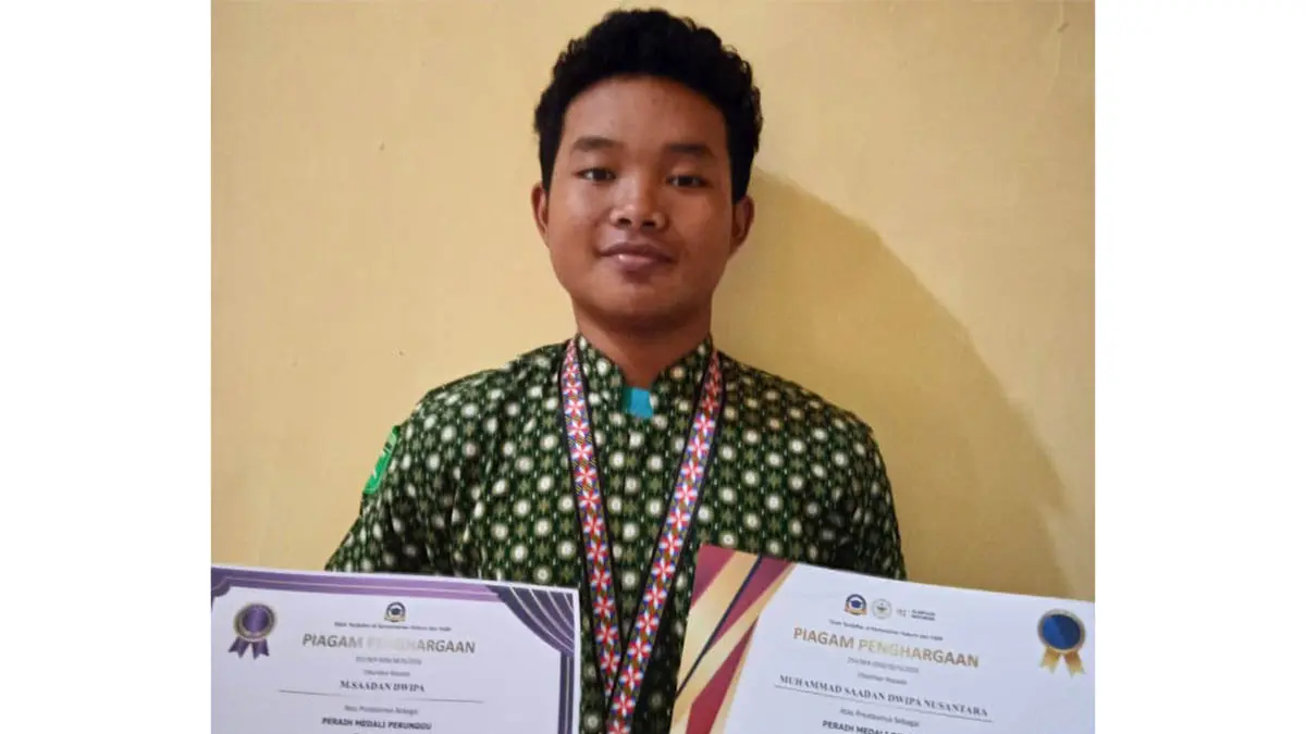 SENANG: Muhammad Saadan Dwipa Nusantara, siswa kelas X-F MAN 2 Kota Probolinggo menunjukkan sertifikat dan medali yang berhasil diraihnya dalam ajang Master Science and Social 2026. (Foto: Istimewa)