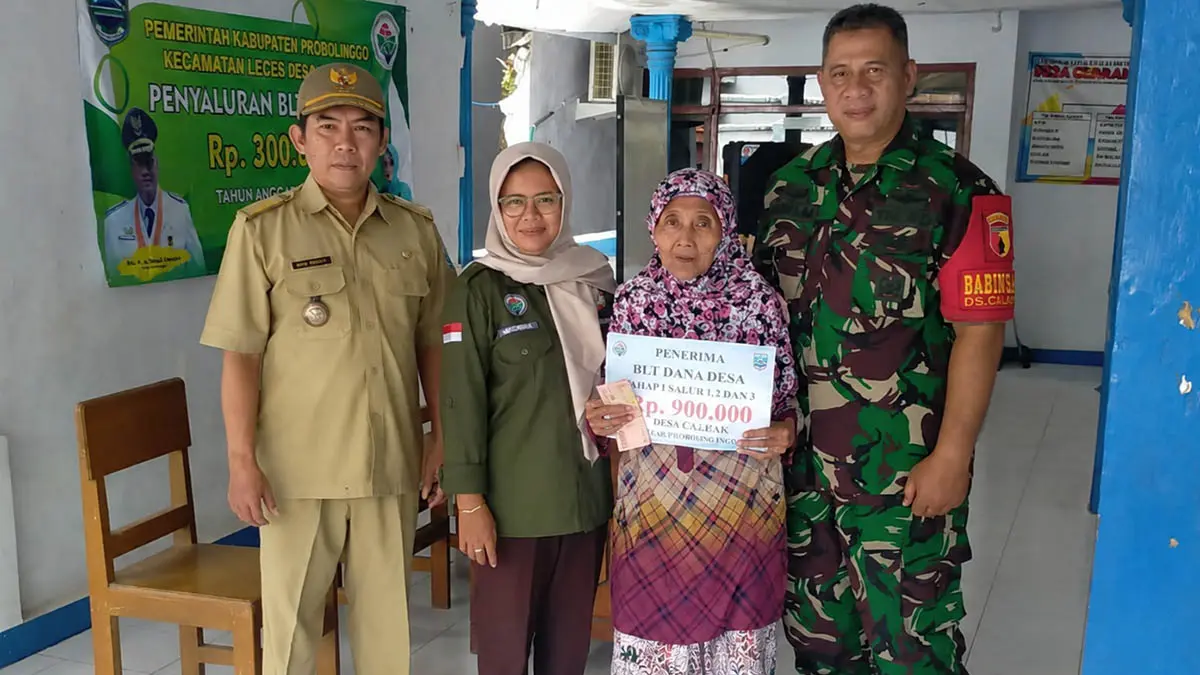 SOSIAL: Kepala Desa Clarak, Imam Hidayat (kiri) menyerahkan bantuan kepada salah satu KPM BLT Dana Desa beberapa waktu lalu. (Foto Jamaludin/Jawa Pos Radar Bromo)