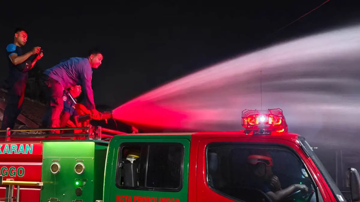 SIRAM: Petugas Damkar Satpol PP Kota Probolinggo saat melakukan pendinginan pada kebakaran lahan di Jalan Slamet Riyadi, Kecamatan Kanigaran, Kota Probolinggo, Jumat (5/6) malam. (Foto: Damkar for Jawa Pos Radar Bromo)