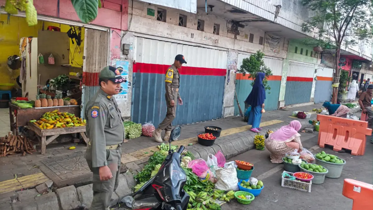 PENERTIBAN: Anggota Satpol PP Kota Probolinggo menertibkan para pedagang di sekitar Pasar Baru Kota Probolinggo, Sabtu (6/6).