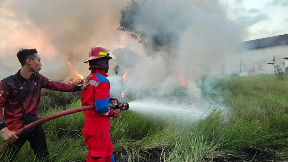 SEMPROT: Petugas Damkar Satpol PP Kota Probolinggo saat melakukan pemadaman di area pemakaman Mbah Bujuk Macan Laut, Kelurahan/Kecamatan Mayangan, yang mengalami kebakaran pada Sabtu (6/6) sore.