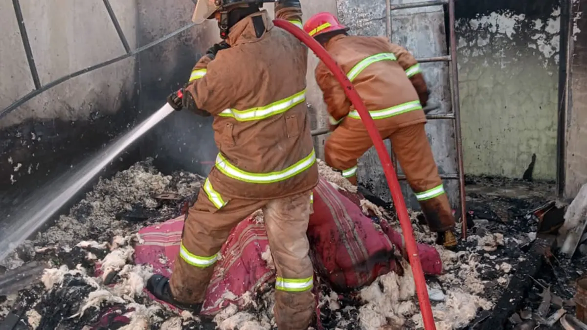 AMUK SI JAGO MERAH: Petugas damkar saat melakukan pembasahan pada kasur di lantai 2 rumah warga Dringu, Probolinggo yang terbakar. 