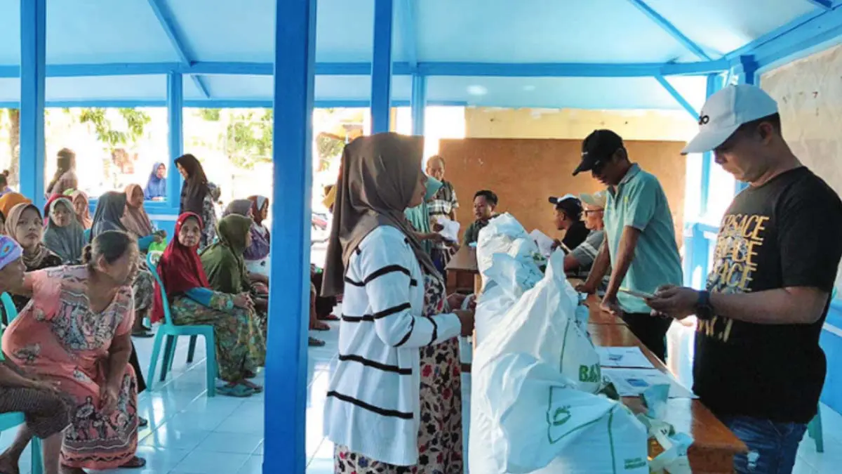 SENANG: Sejumlah warga menerima bantuan pangan di Balai Desa Warujinggo&nbsp;